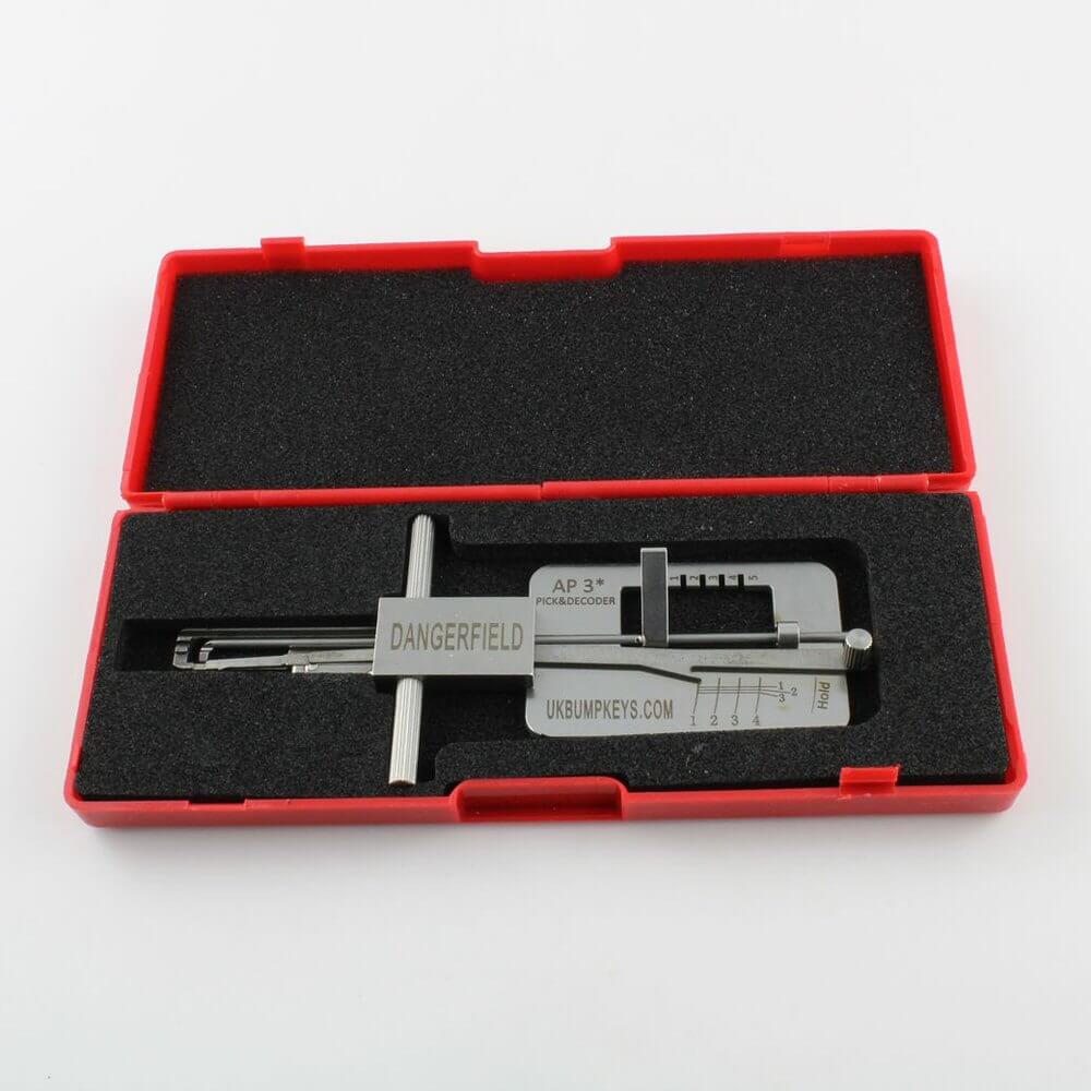 Metal Dangerfield APECS Lock Picking tool with engraved text, in a case, on a white background