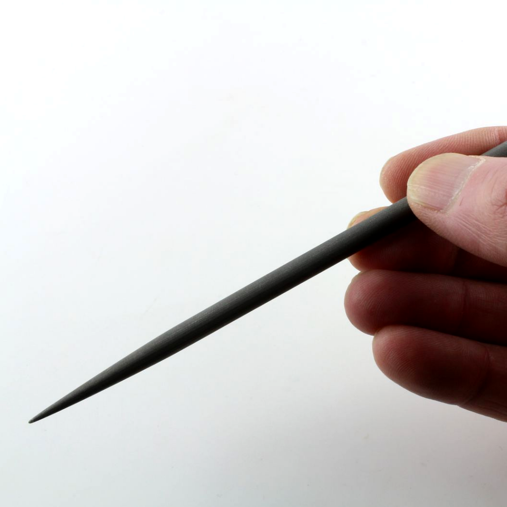 Hand holding an impressioning file on a white background