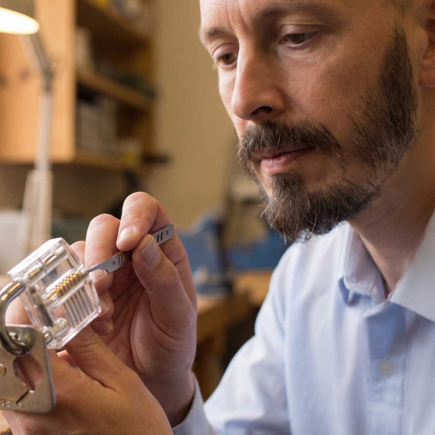 Chris Dangerfield at the workshop vice holding a padlock