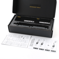 Open black box containing Dangerfield Machina, tools, with manual on a white background